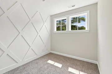 Carpeted bedroom with a panelled accent wall